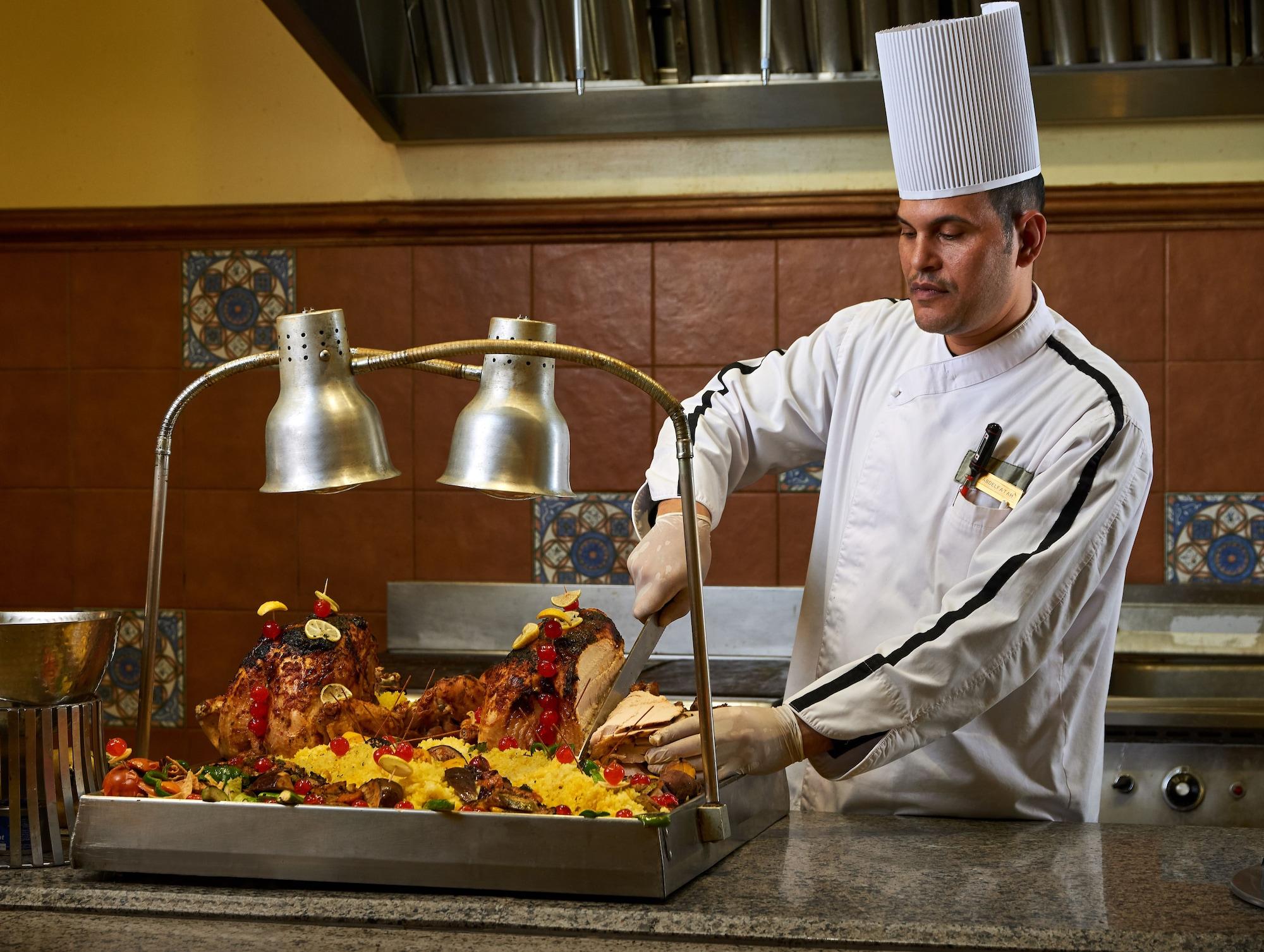 Mosaique Beach Resort Taba Heights Buitenkant foto A chef carving a roast